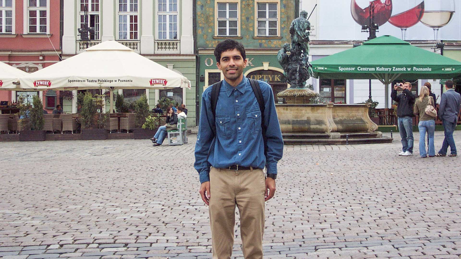 Me standing in a cobblestone plaza with tents and shops in the background