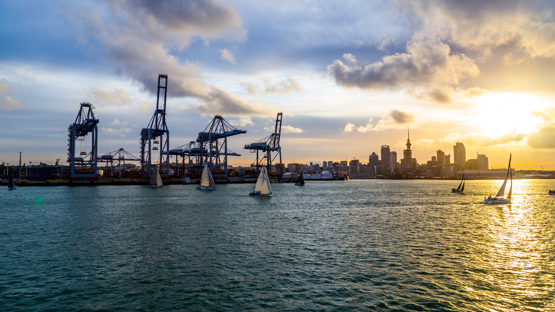 Container port and city skyline with a sunset in the sky