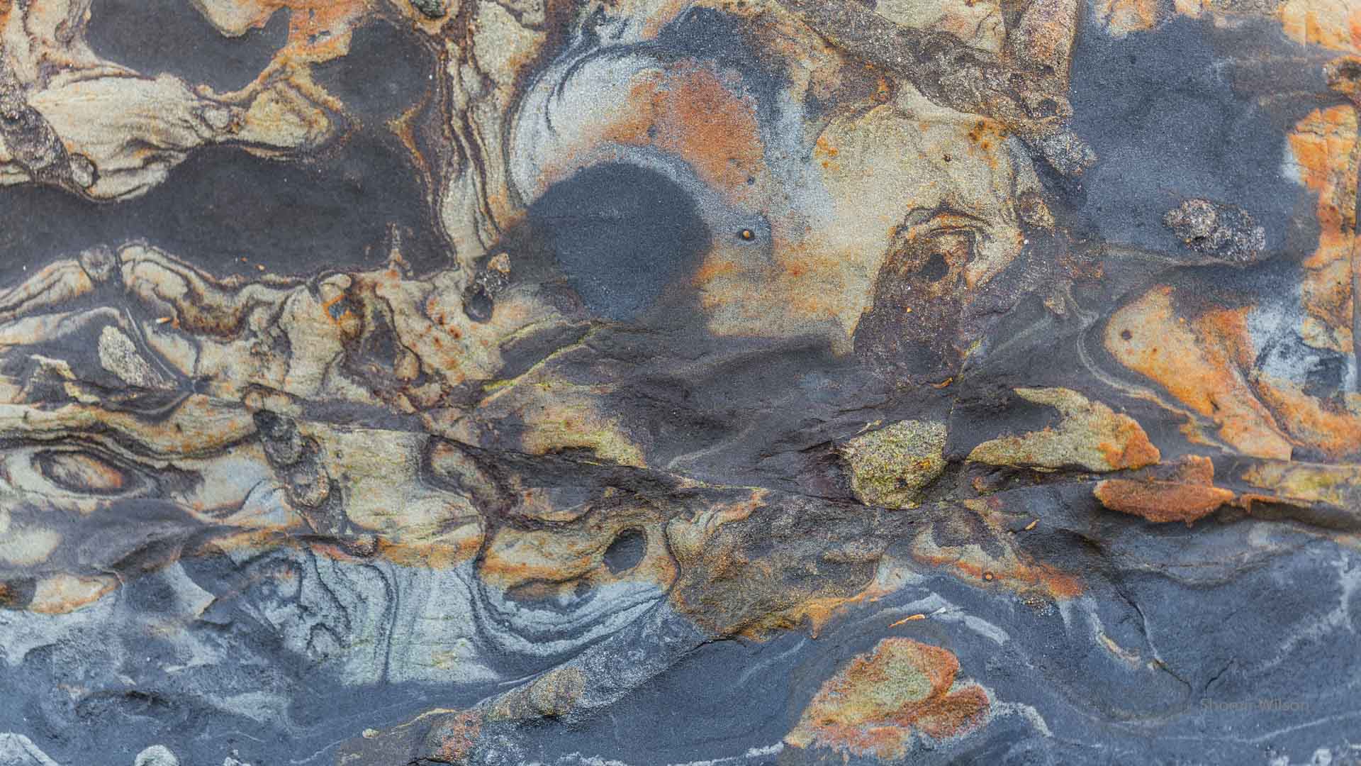 colorful swirling patters in a rock face