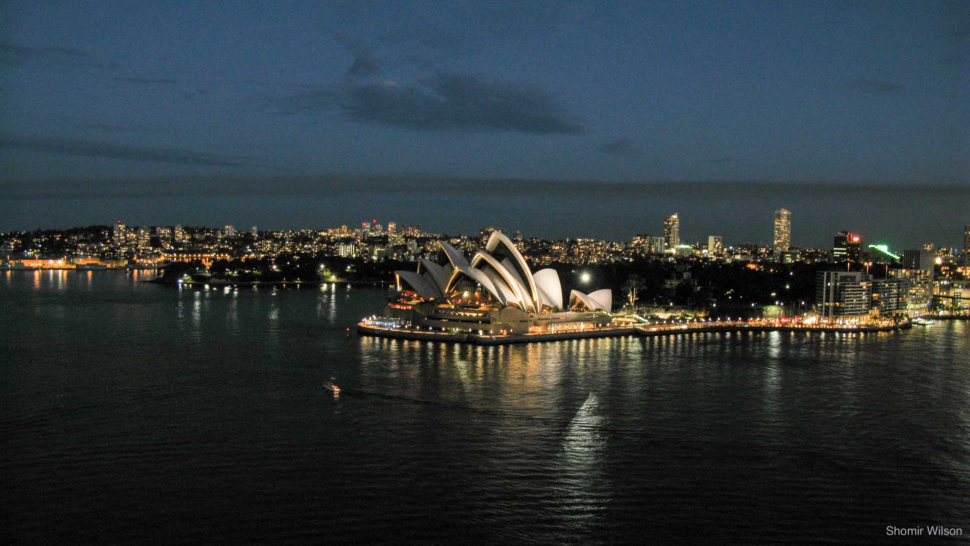 Sydney Harbour and the Sydney Opera House at night.