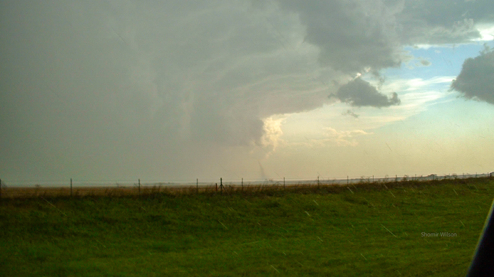 Dramatic clouds with a distant tornado over plains