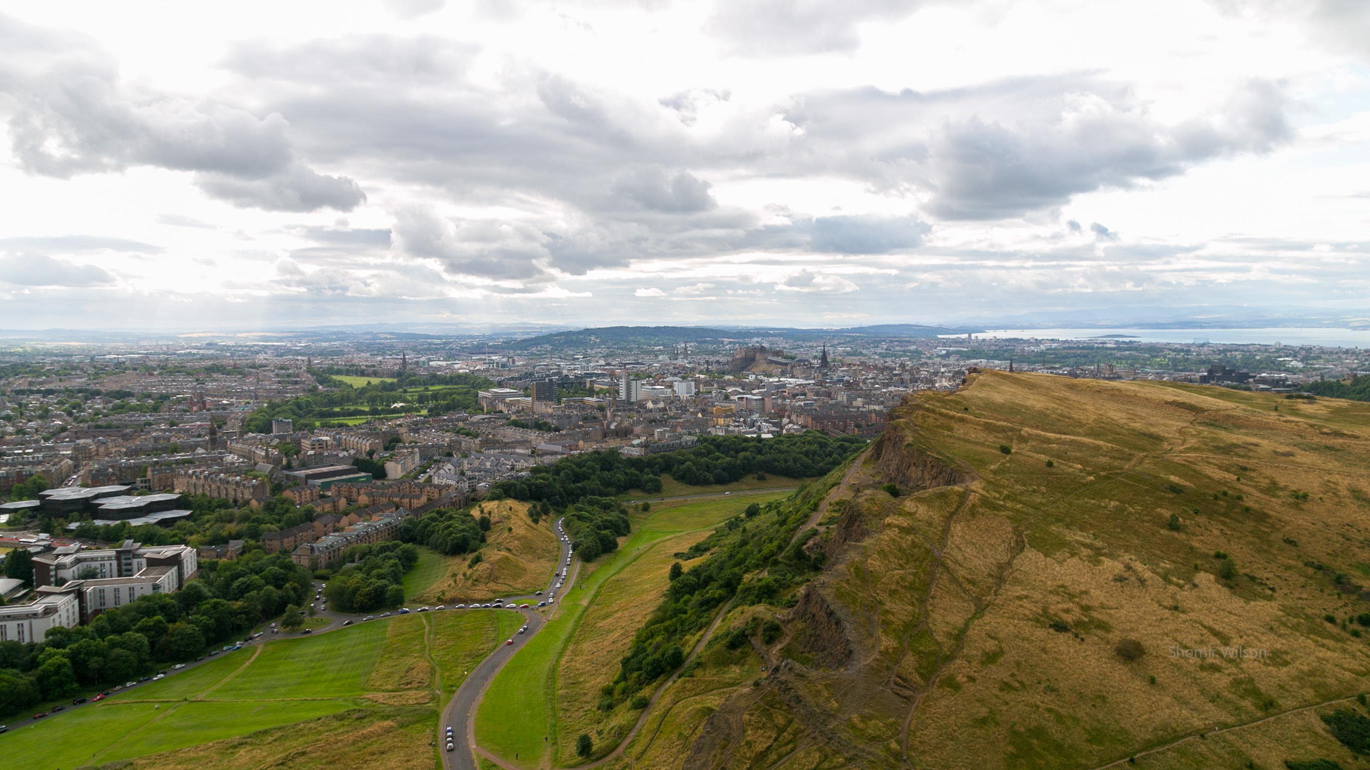 Scottish city with clouds above, from a tall hill nearby